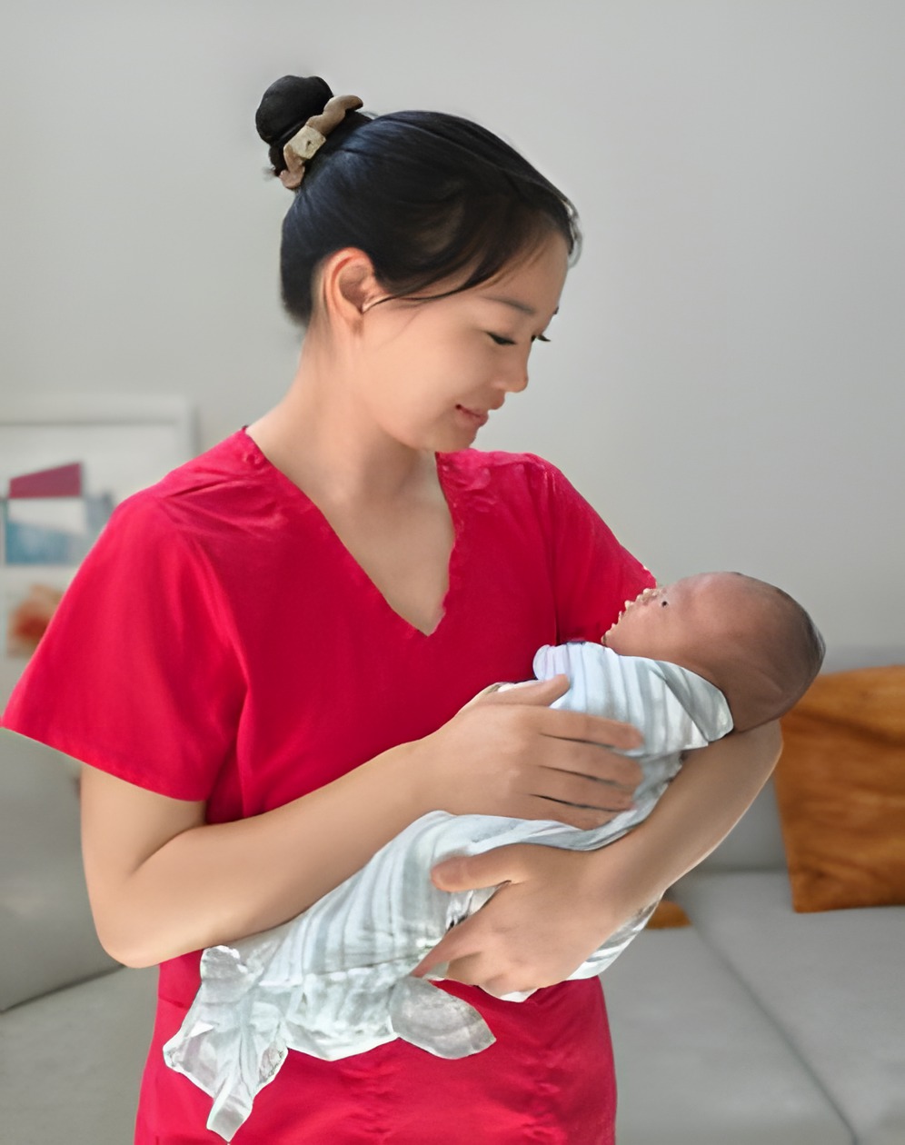 冯玉娟抱着新生儿 / Cindy Feng holding a newborn
