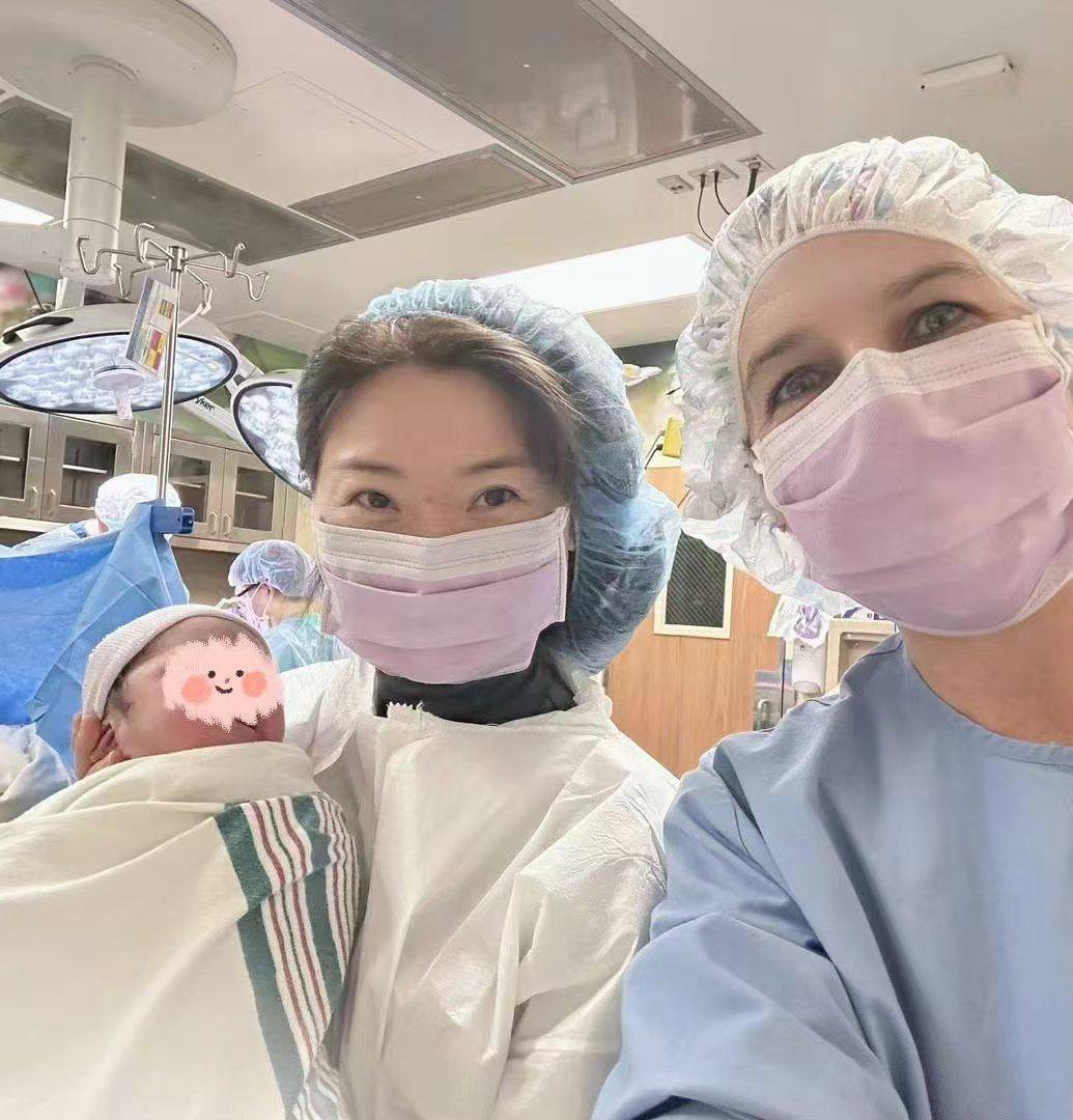 Cindy Feng in the delivery room holding a newborn