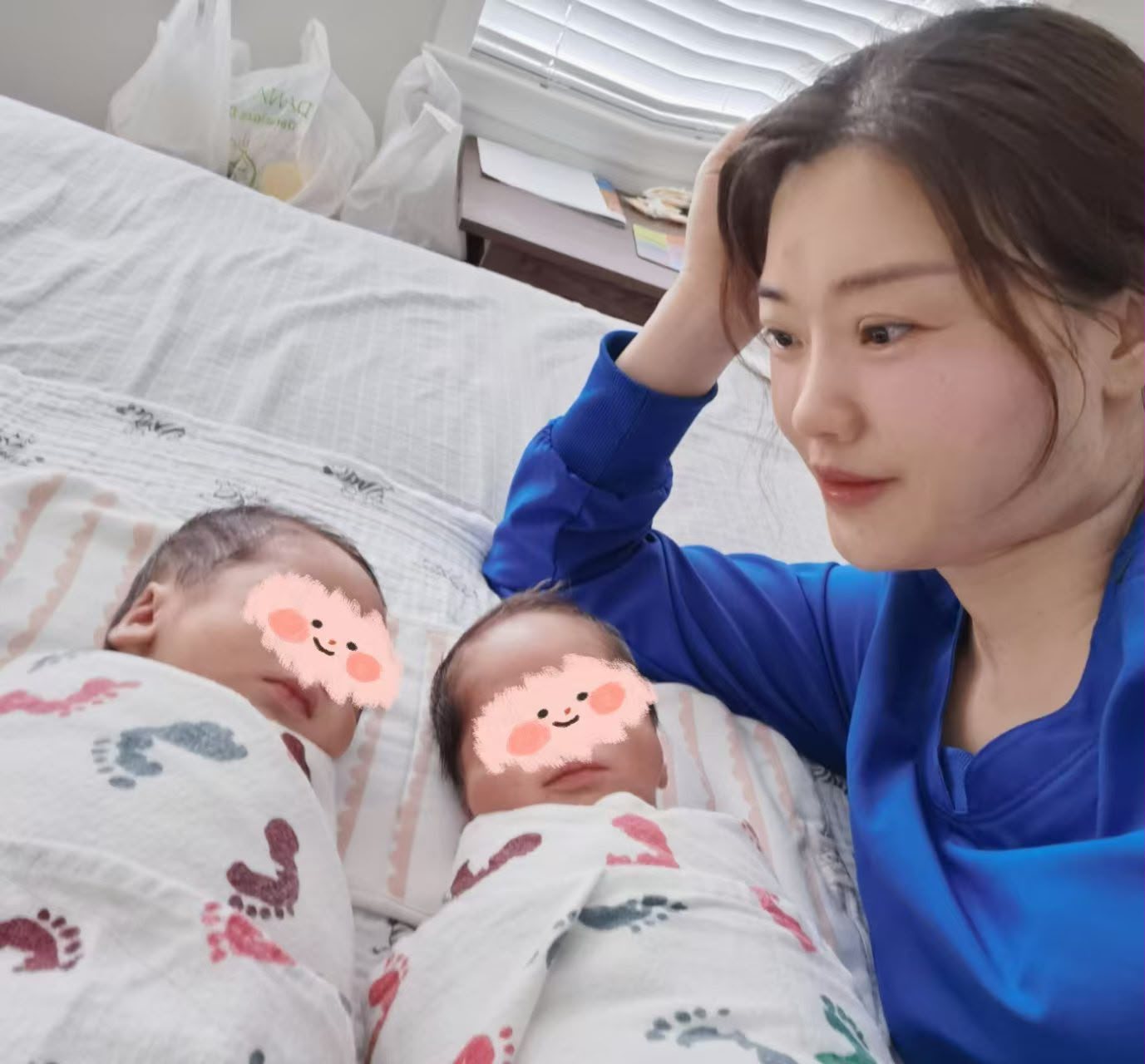 Cindy Feng watching over swaddled newborn twins