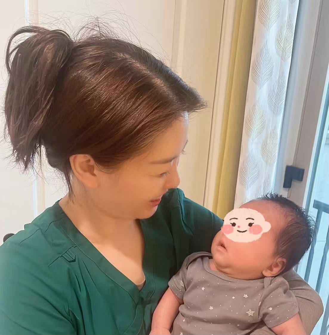 Cindy Feng smiling at a newborn she is holding
